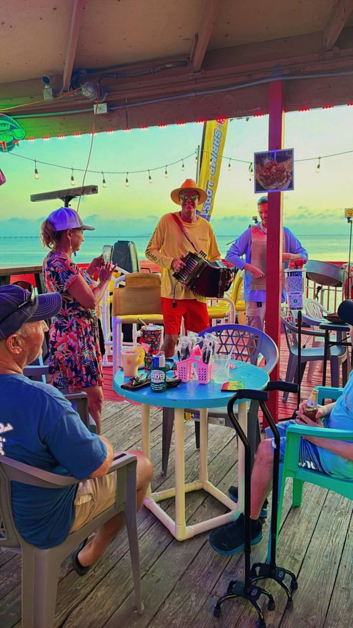 Live accordion music at sunset on the Pineapple Ninjaz waterfront deck